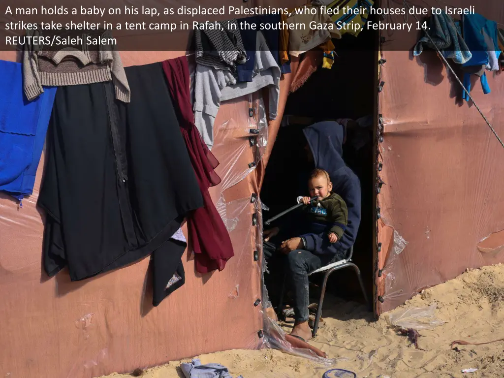 a man holds a baby on his lap as displaced