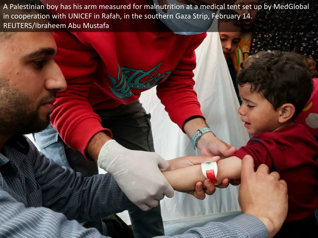 a palestinian boy has his arm measured