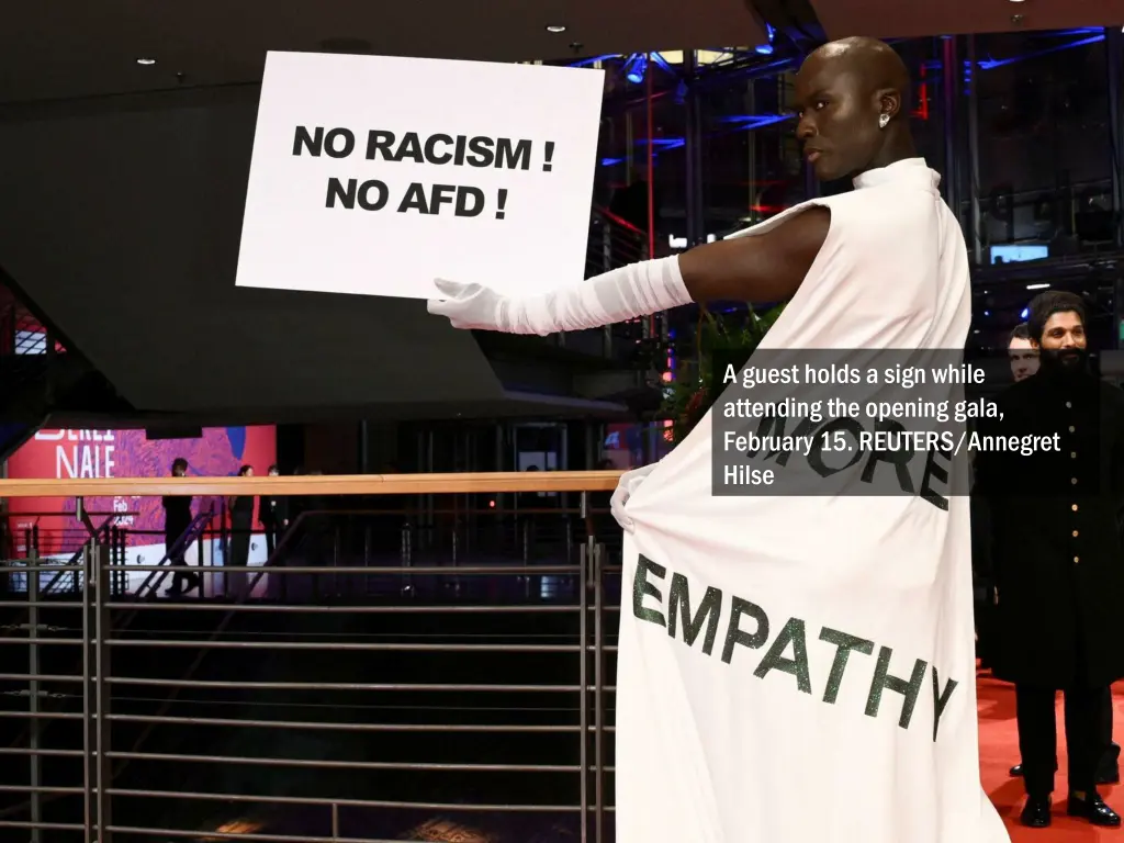 a guest holds a sign while attending the opening