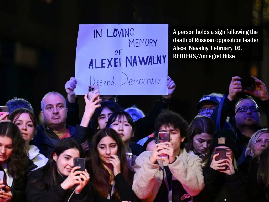 a person holds a sign following the death