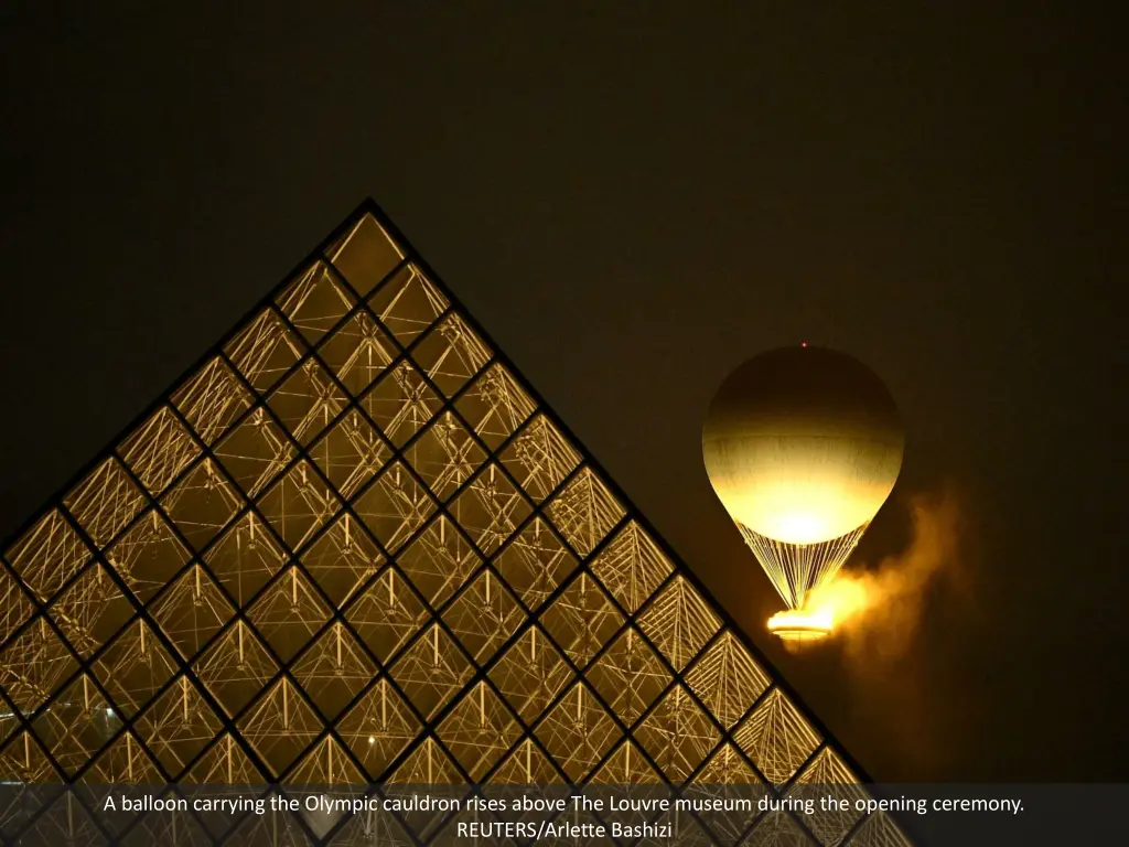 a balloon carrying the olympic cauldron rises