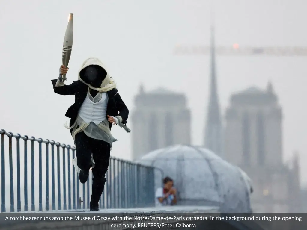 a torchbearer runs atop the musee d orsay with