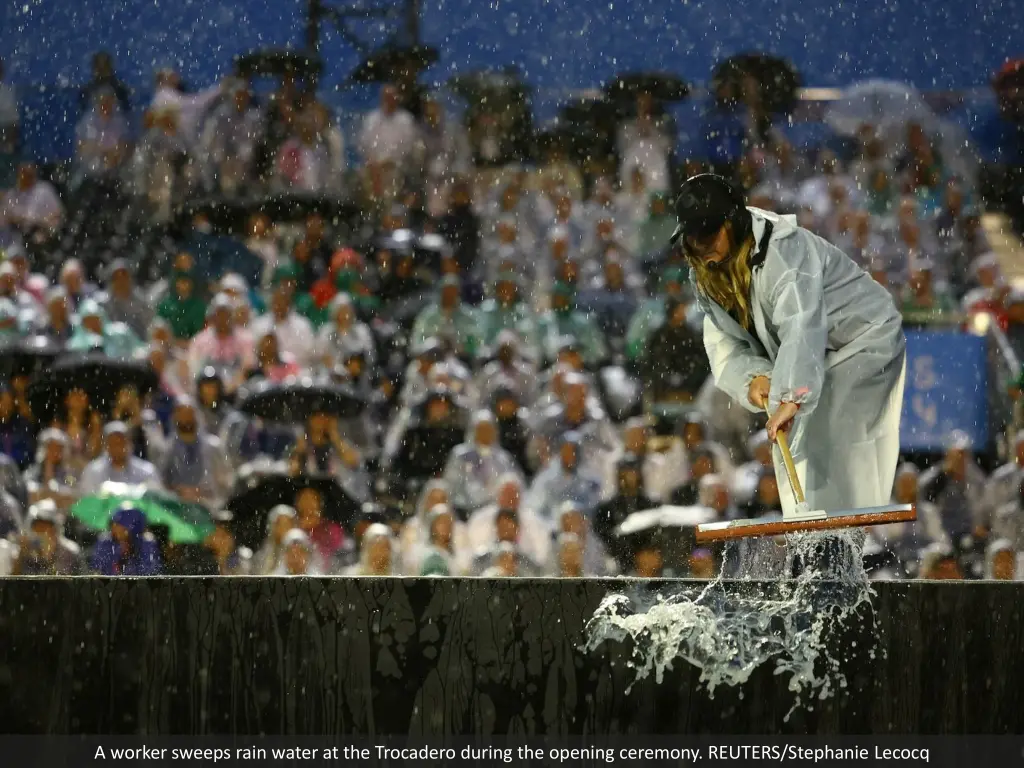 a worker sweeps rain water at the trocadero