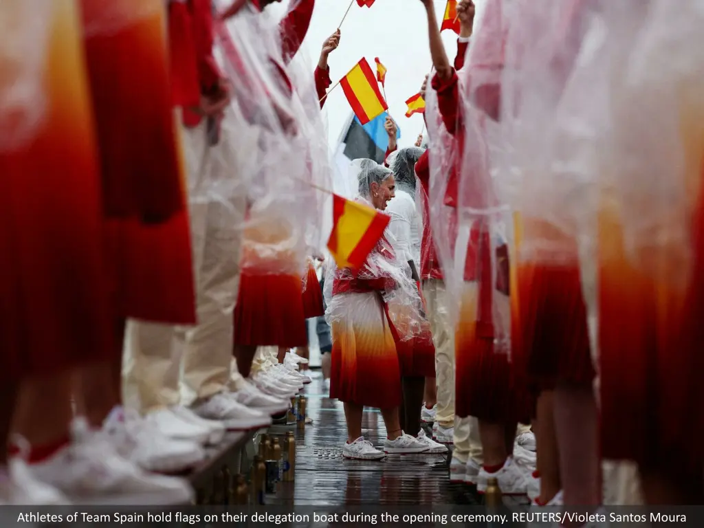 athletes of team spain hold flags on their