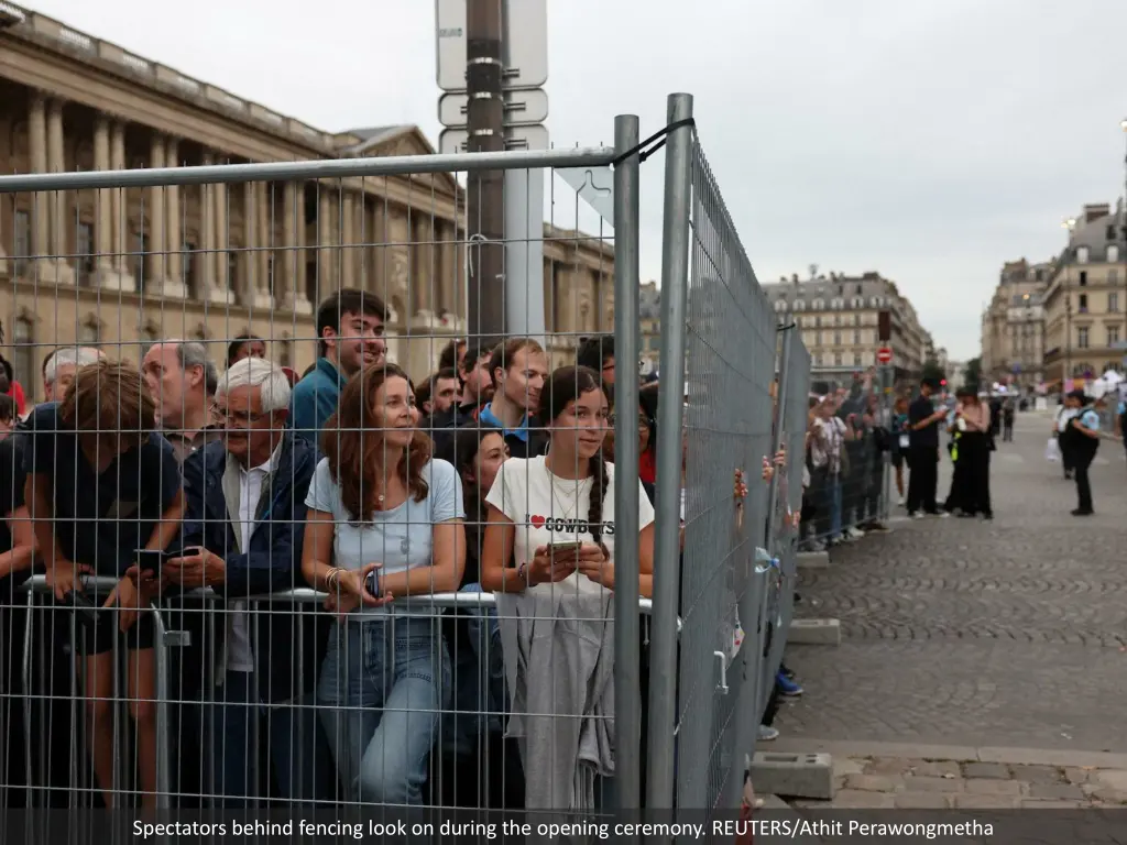 spectators behind fencing look on during