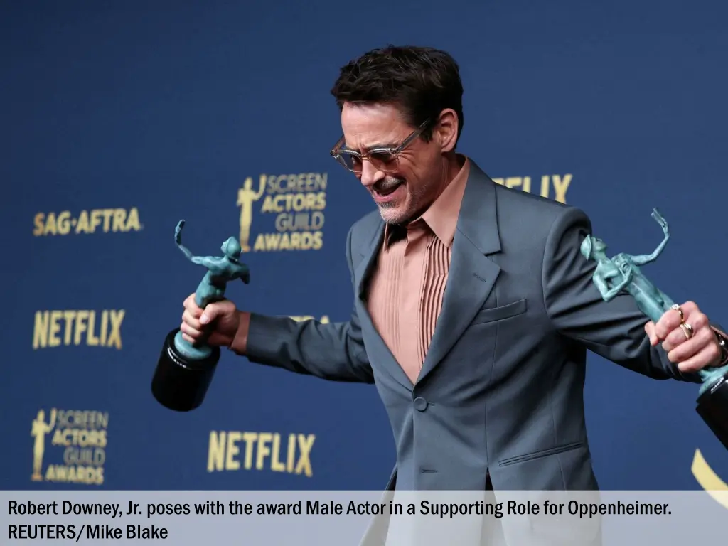 robert downey jr poses with the award male actor