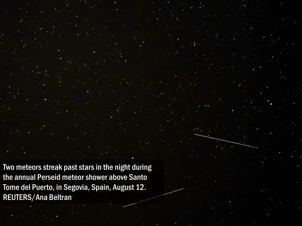 two meteors streak past stars in the night during