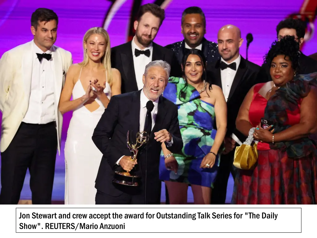 jon stewart and crew accept the award