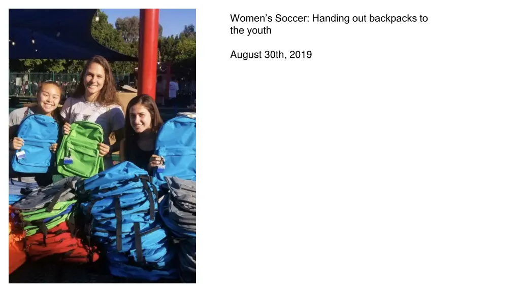 women s soccer handing out backpacks to the youth