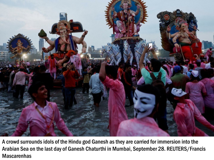 a crowd surrounds idols of the hindu god ganesh