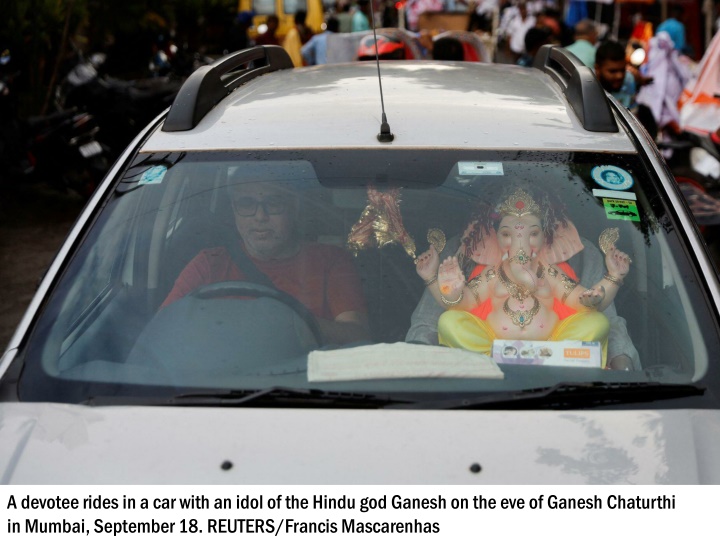 a devotee rides in a car with an idol