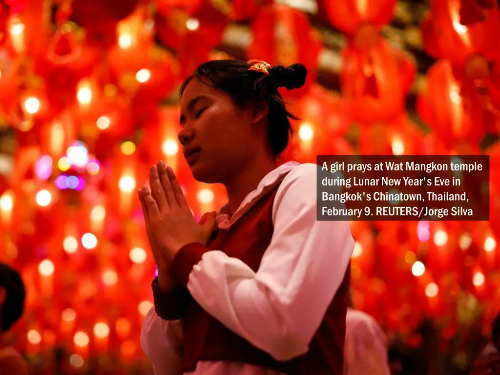 a girl prays at wat mangkon temple during lunar