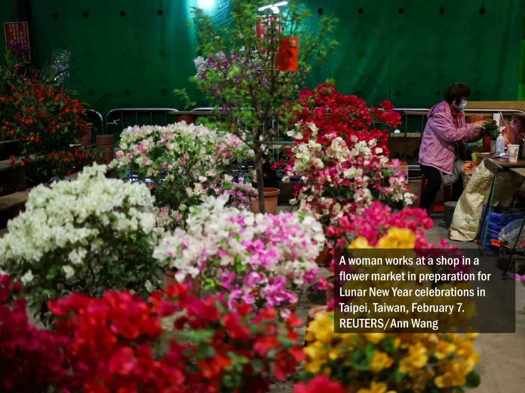 a woman works at a shop in a flower market