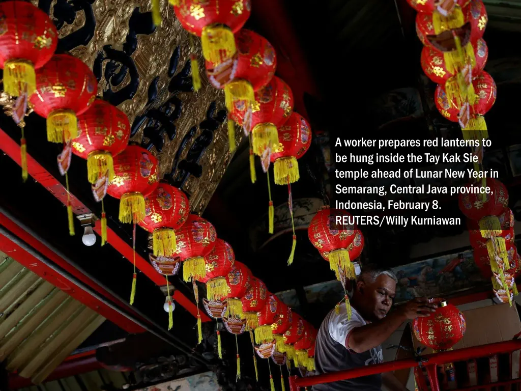 a worker prepares red lanterns to be hung inside