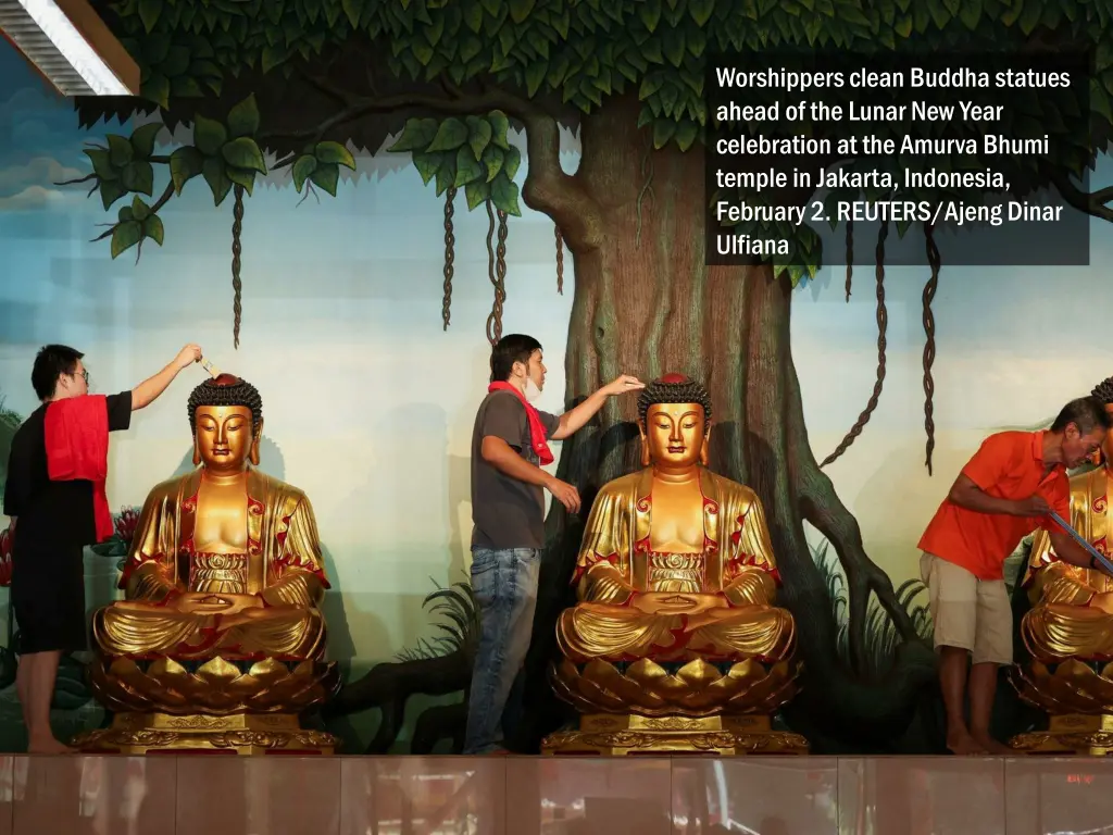 worshippers clean buddha statues ahead