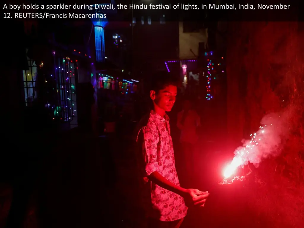 a boy holds a sparkler during diwali the hindu