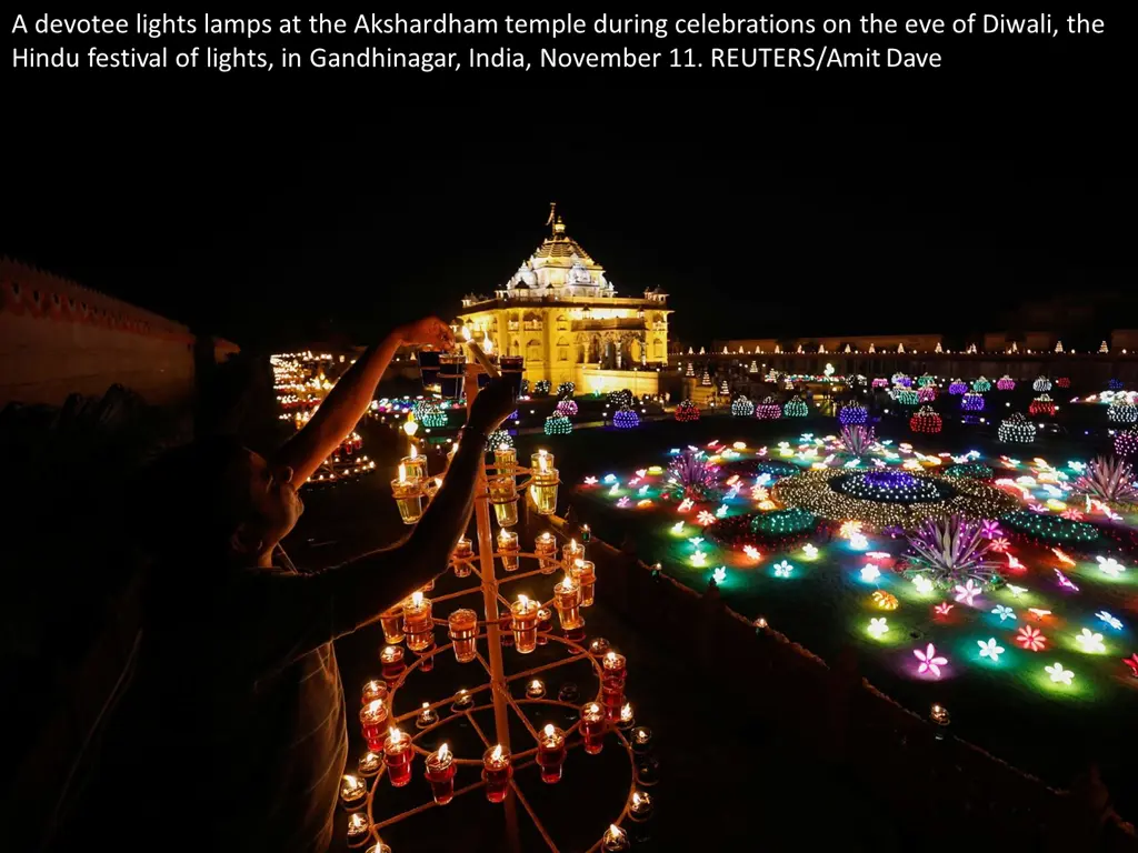 a devotee lights lamps at the akshardham temple