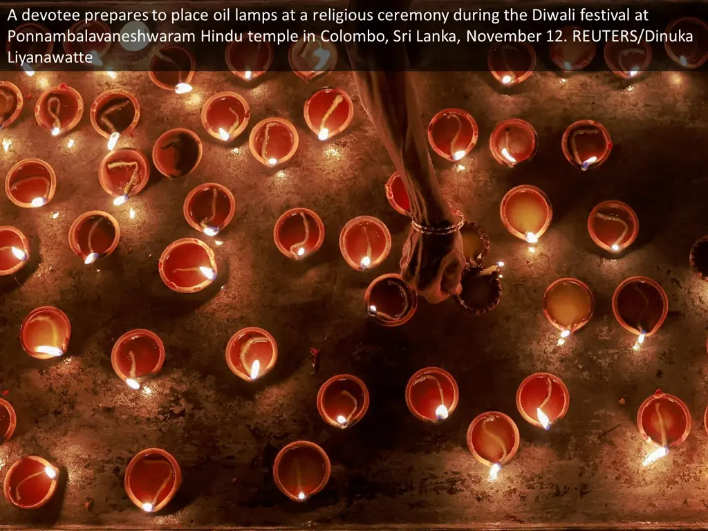 a devotee prepares to place oil lamps