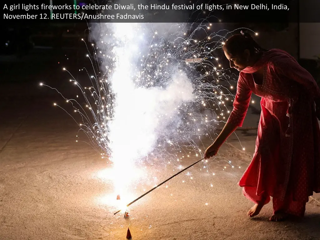 a girl lights fireworks to celebrate diwali