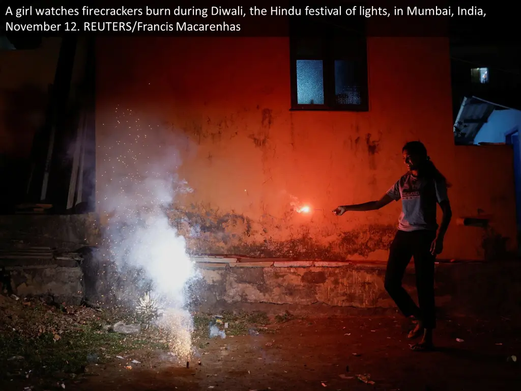 a girl watches firecrackers burn during diwali