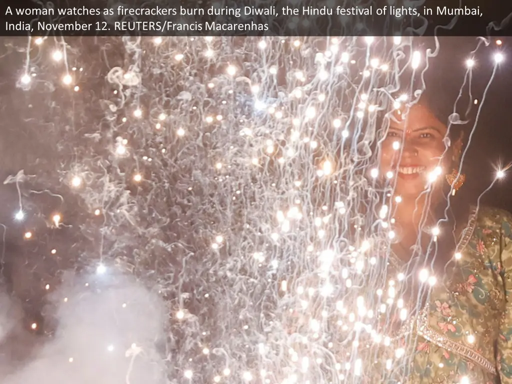 a woman watches as firecrackers burn during