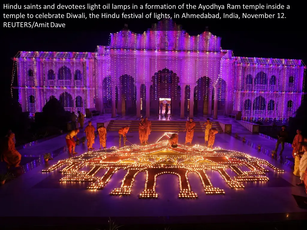 hindu saints and devotees light oil lamps