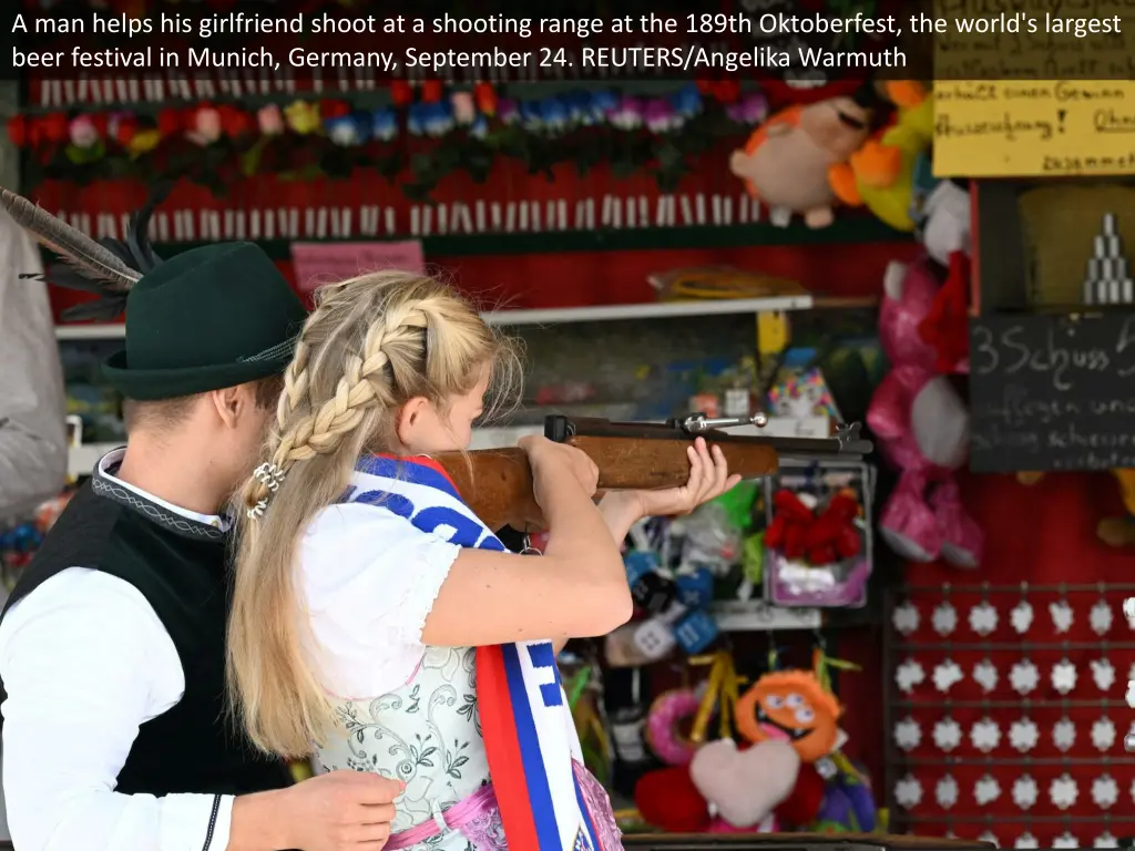 a man helps his girlfriend shoot at a shooting