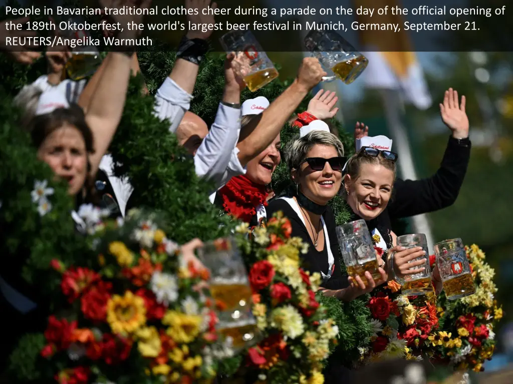 people in bavarian traditional clothes cheer