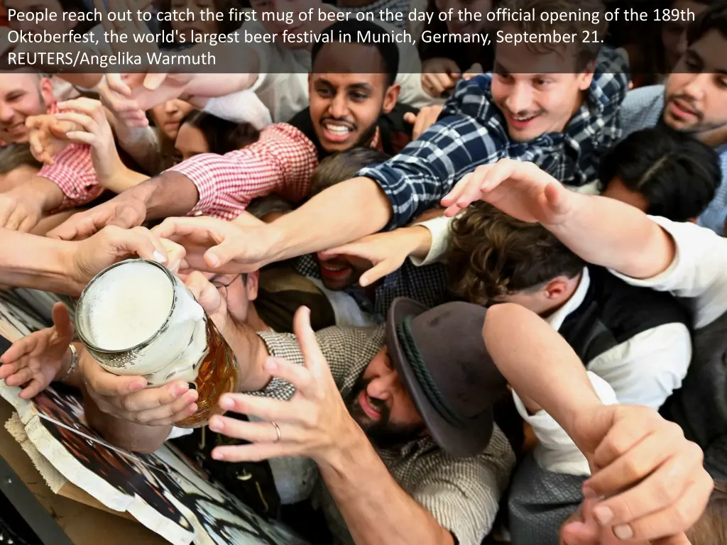 people reach out to catch the first mug of beer