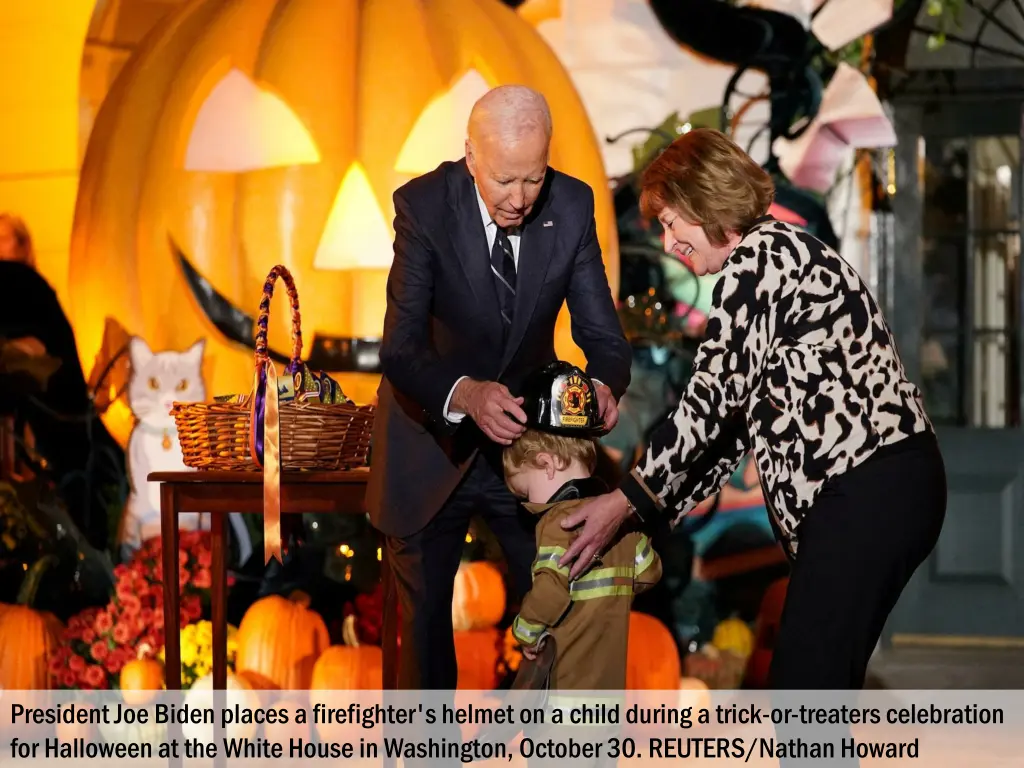 president joe biden places a firefighter s helmet