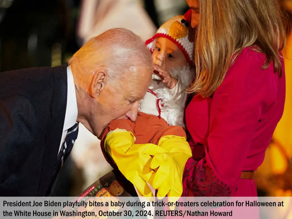 president joe biden playfully bites a baby during