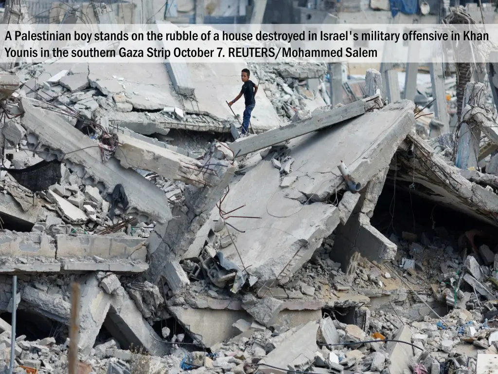 a palestinian boy stands on the rubble of a house