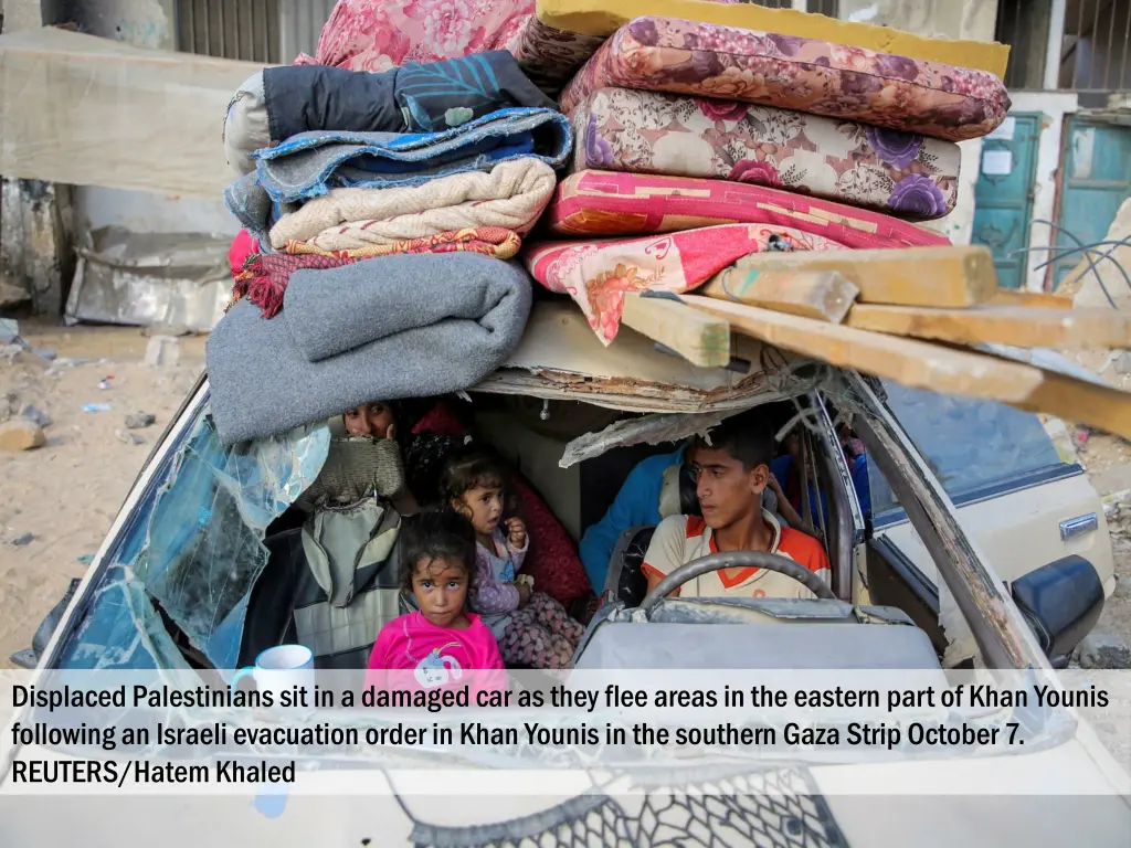 displaced palestinians sit in a damaged