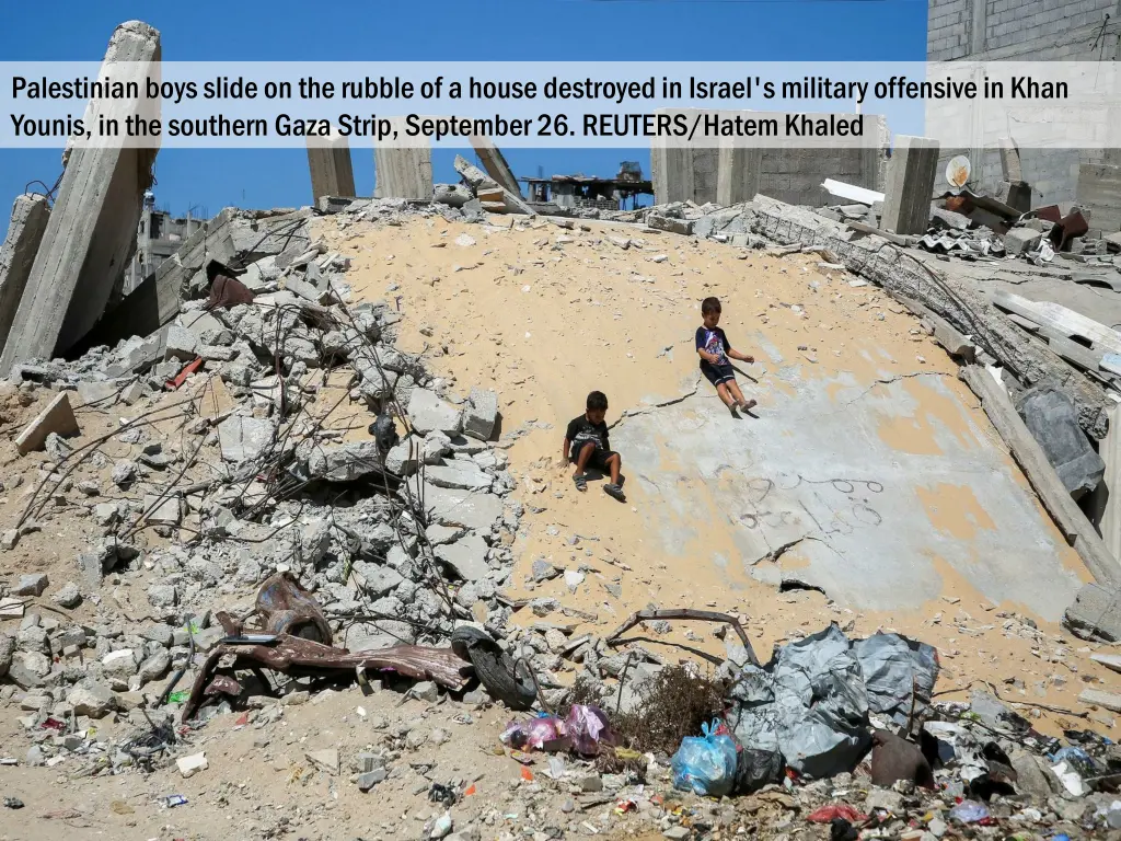 palestinian boys slide on the rubble of a house