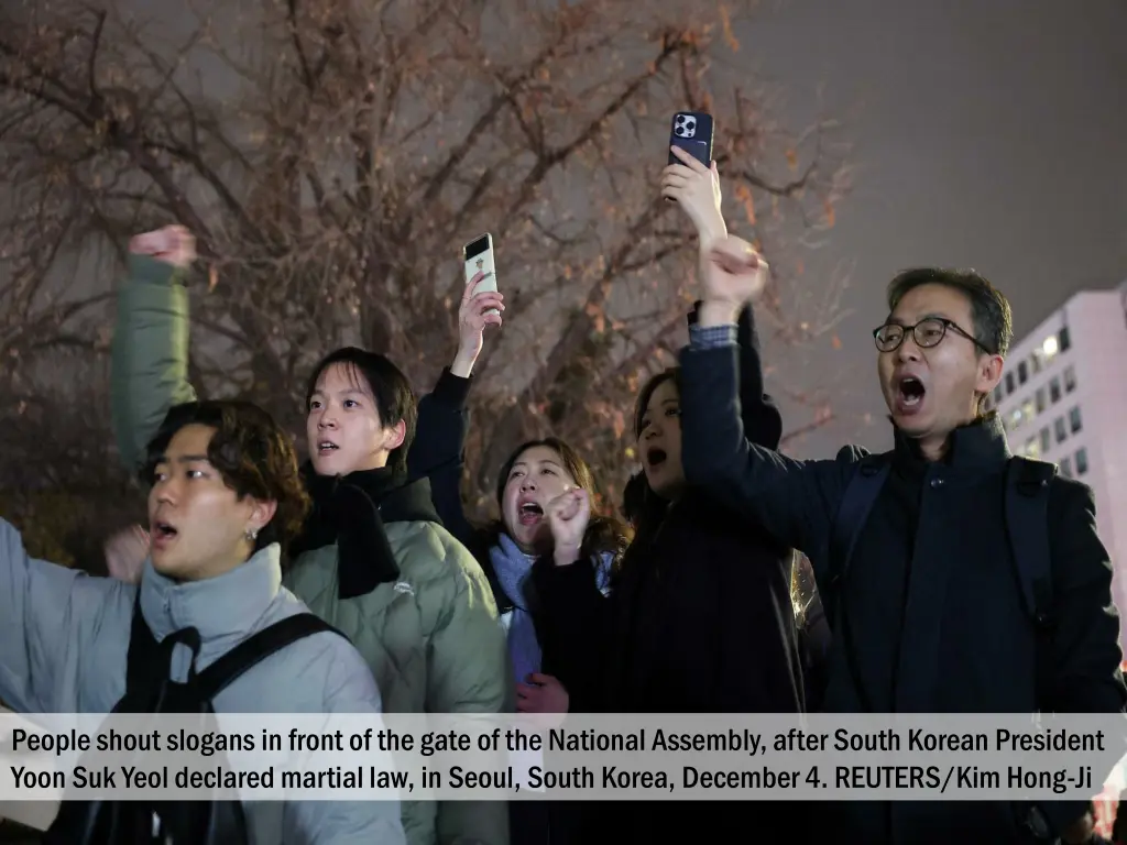 people shout slogans in front of the gate