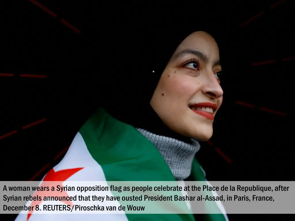 a woman wears a syrian opposition flag as people