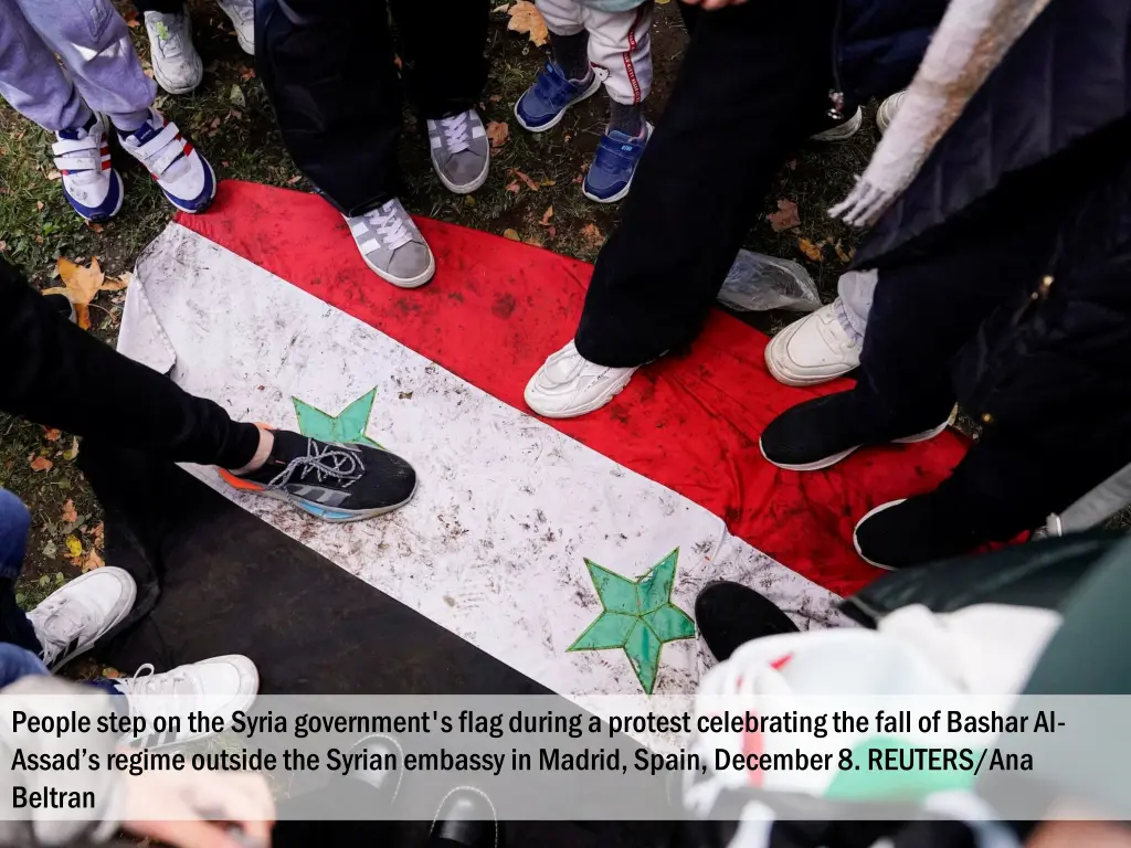 people step on the syria government s flag during