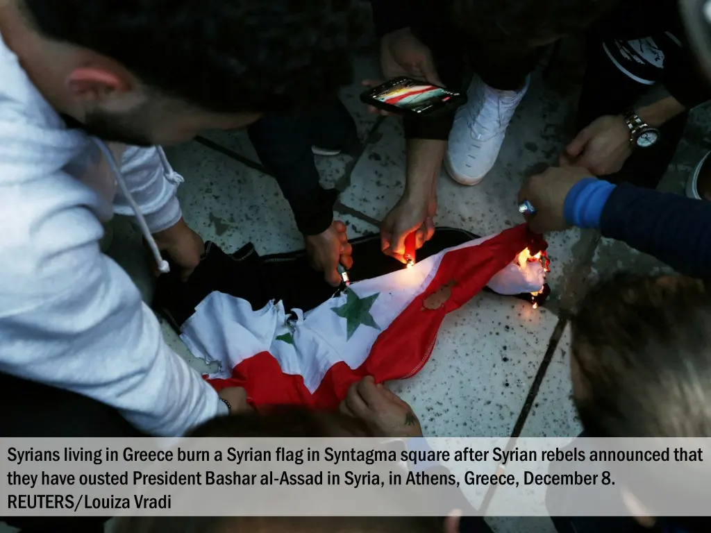 syrians living in greece burn a syrian flag