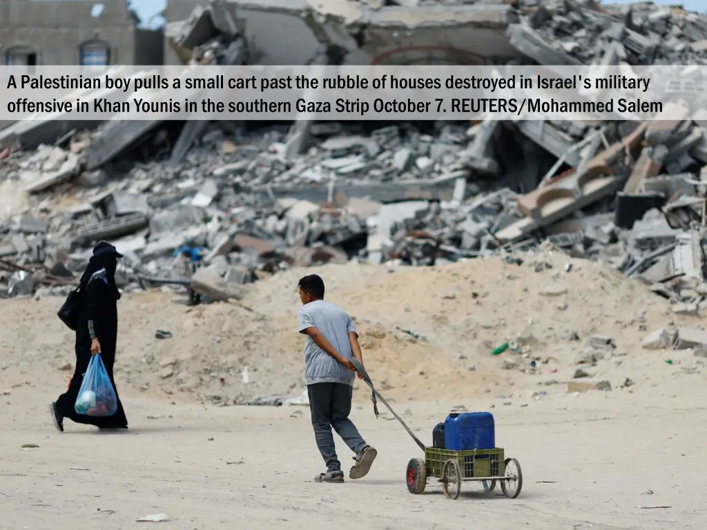 a palestinian boy pulls a small cart past