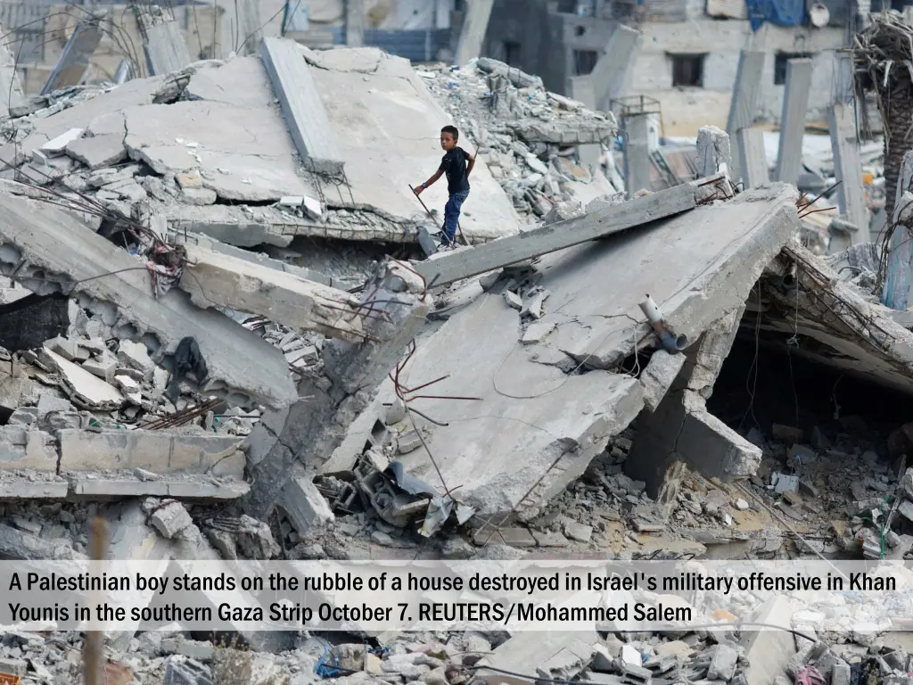 a palestinian boy stands on the rubble of a house