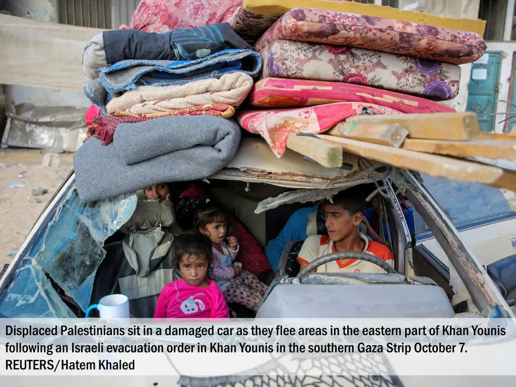 displaced palestinians sit in a damaged