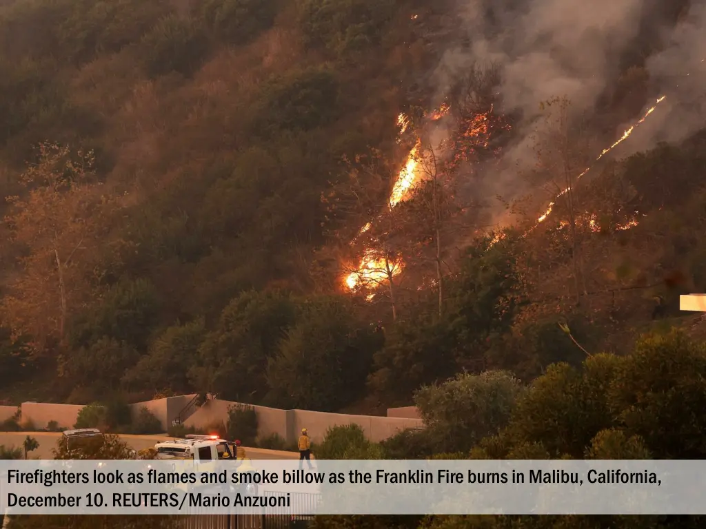 firefighters look as flames and smoke billow