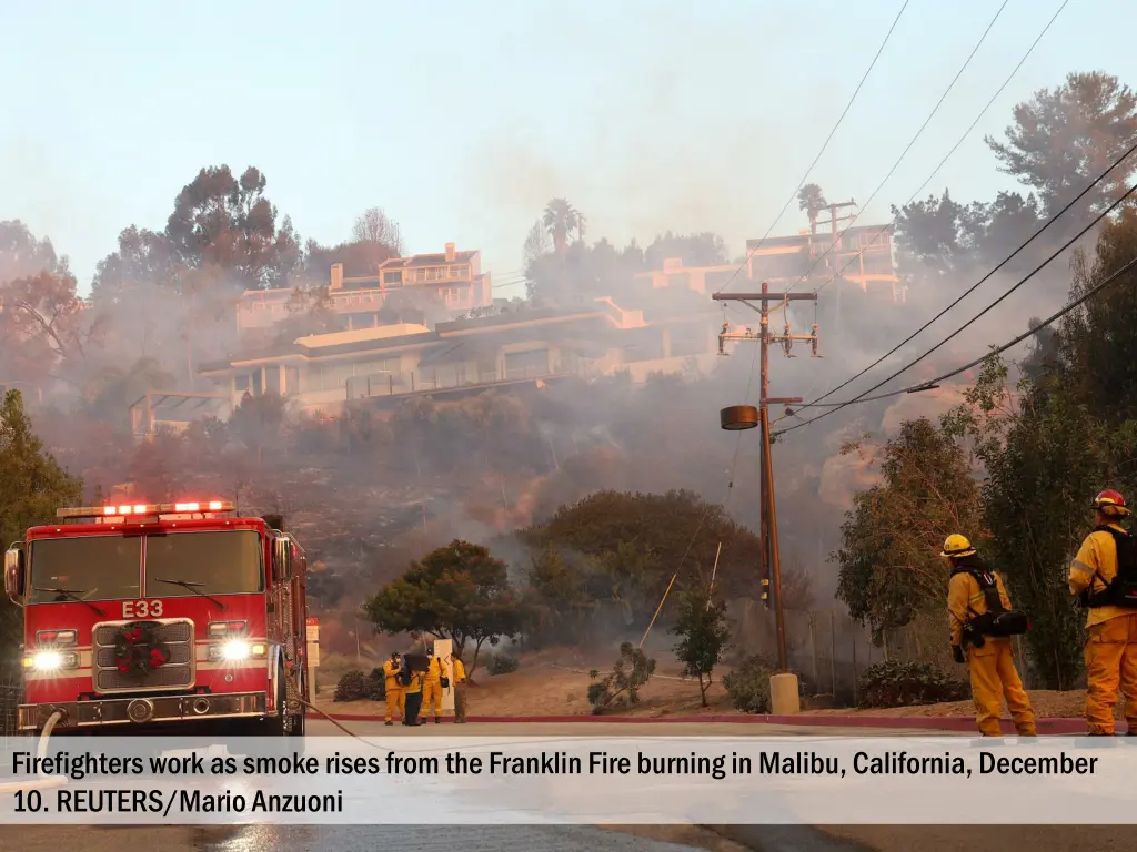 firefighters work as smoke rises from