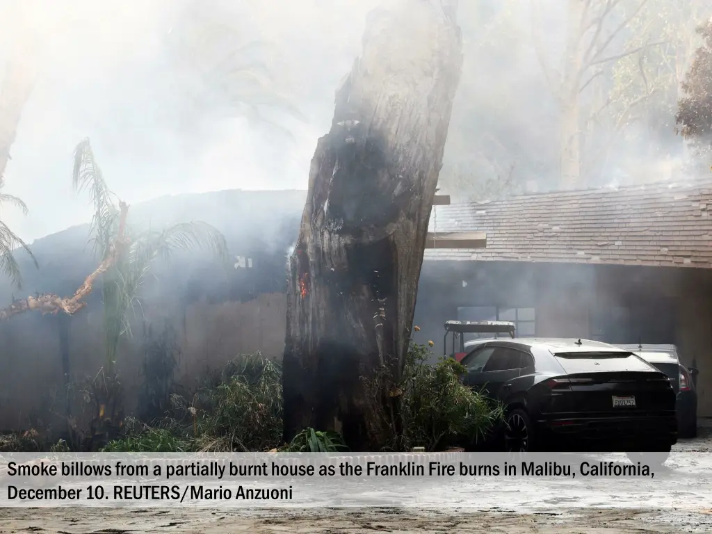 smoke billows from a partially burnt house