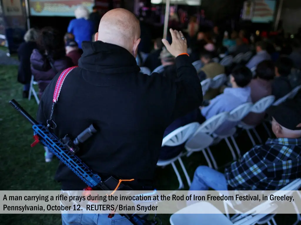 a man carrying a rifle prays during