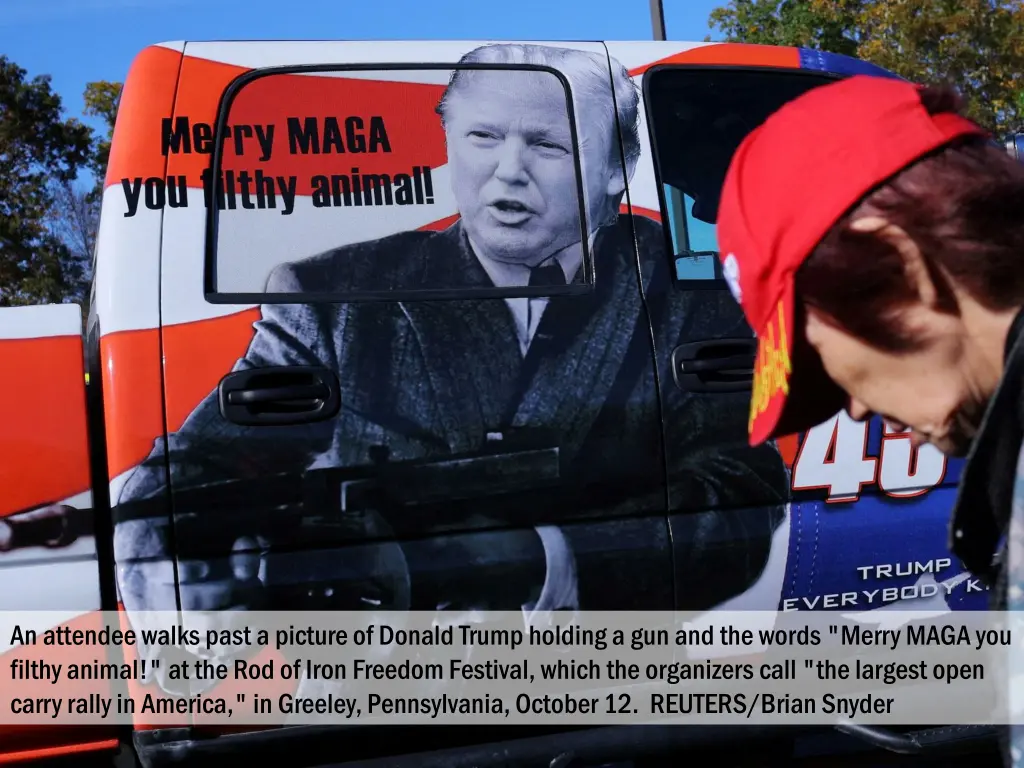 an attendee walks past a picture of donald trump