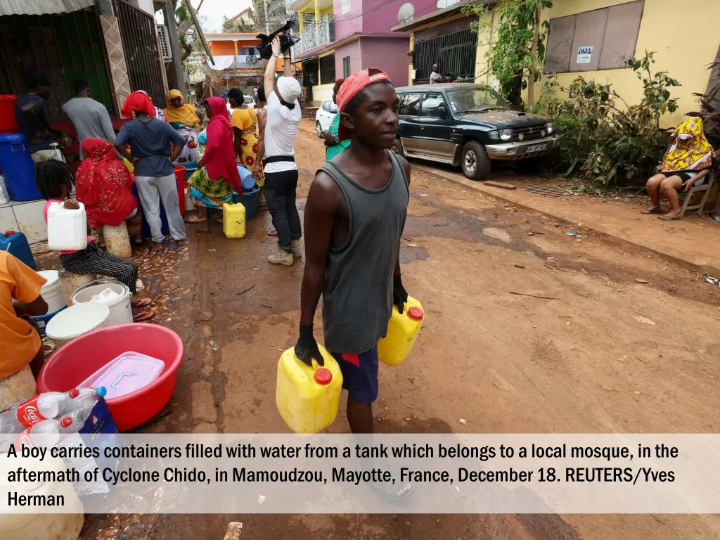 a boy carries containers filled with water from