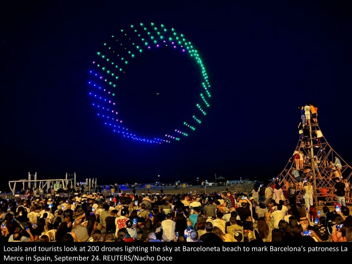 locals and tourists look at 200 drones lighting