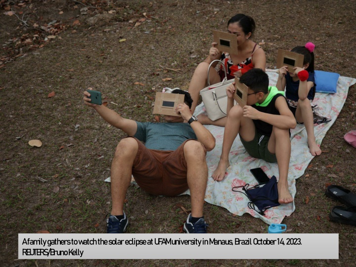 a family gathers to watch the solar eclipse