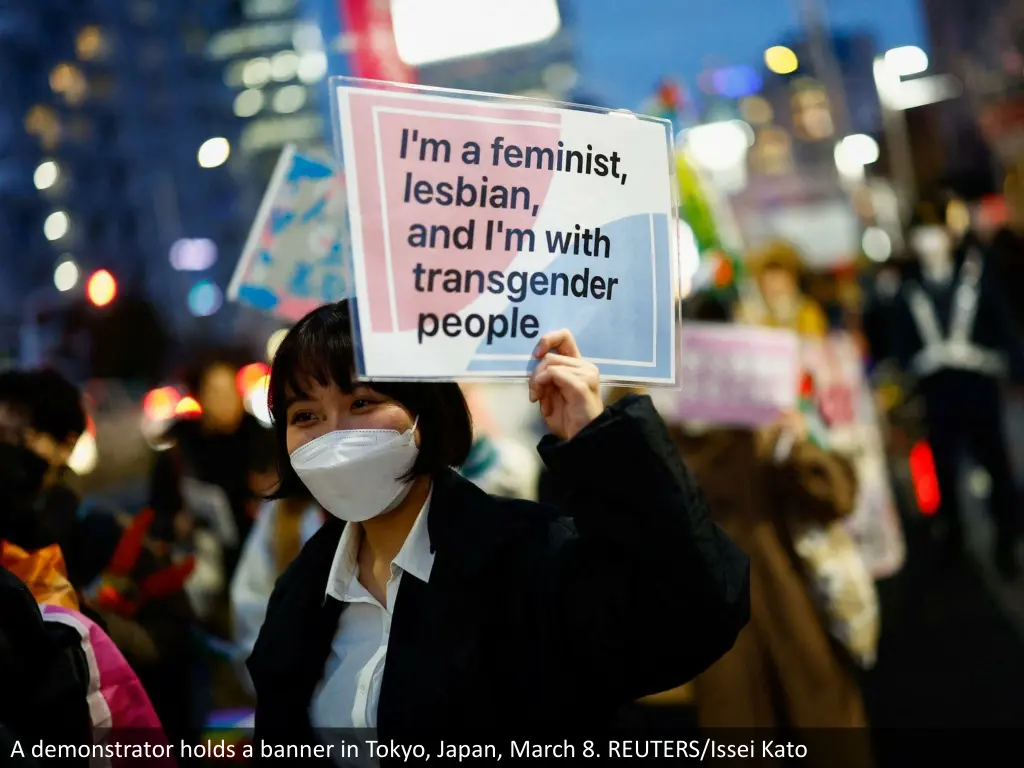 a demonstrator holds a banner in tokyo japan